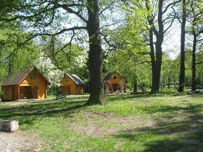 Widok od strony plaży na pozostałe 3 domki  - między domkami palc z huśtawkami i miejscem na ognisko